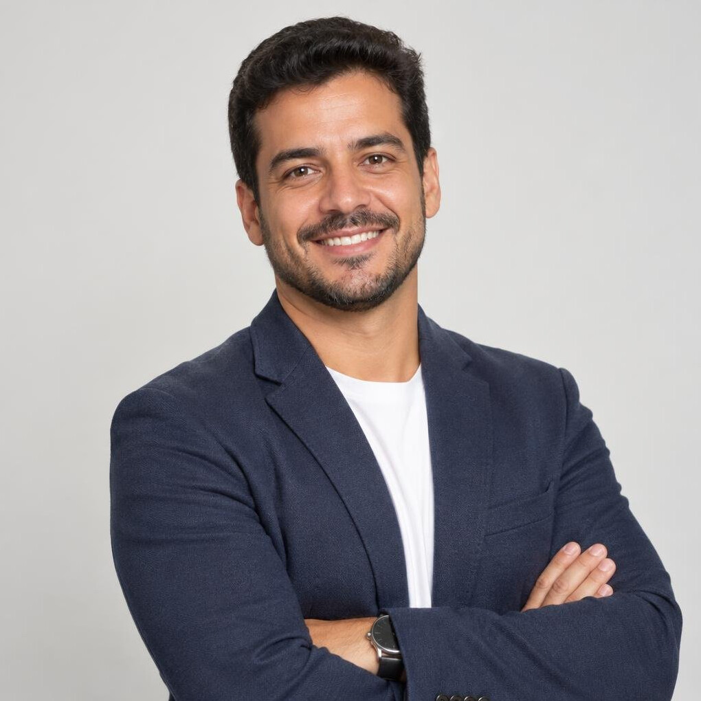 Smiling man in a blazer with arms crossed